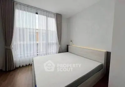 Modern bedroom with large window and stylish curtains in a minimalist design.