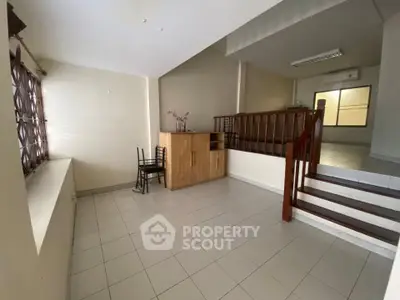 Spacious interior with tiled flooring and wooden accents, ideal for versatile living space.