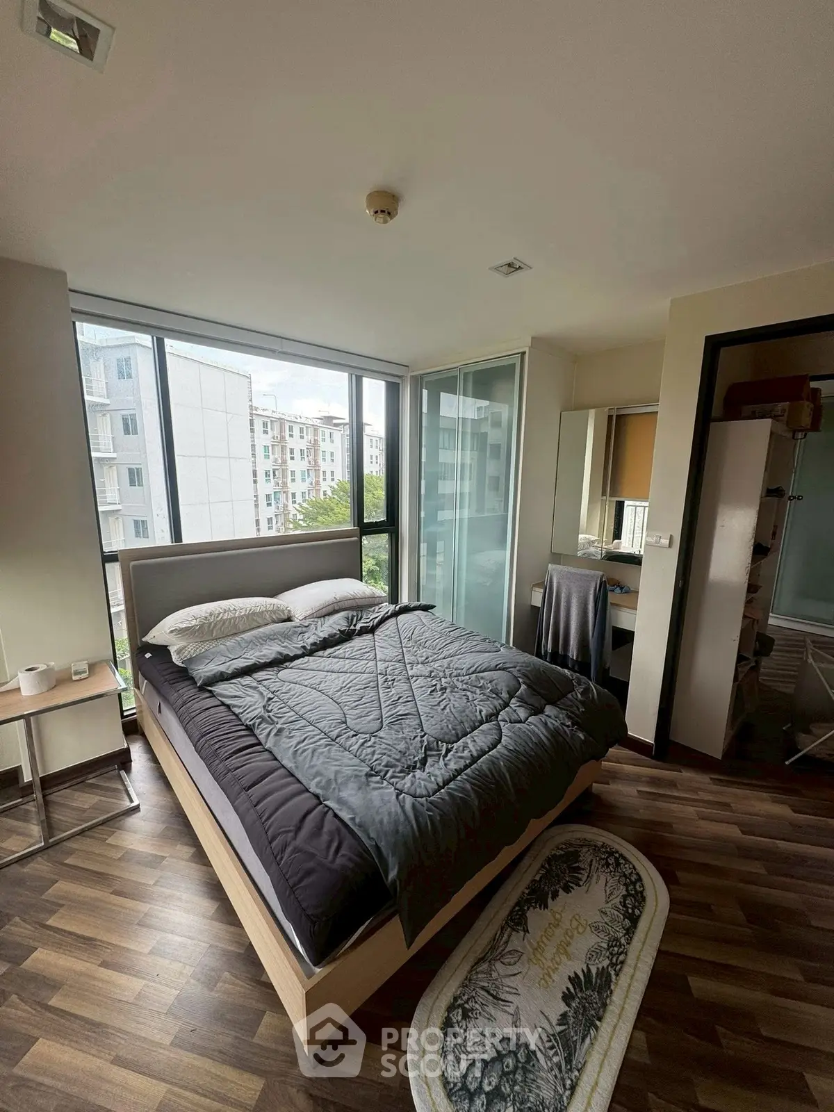 Modern bedroom with large windows and stylish decor in urban apartment