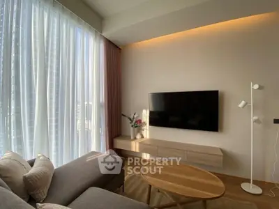 Modern living room with sleek TV setup and stylish furniture in a bright, airy space.