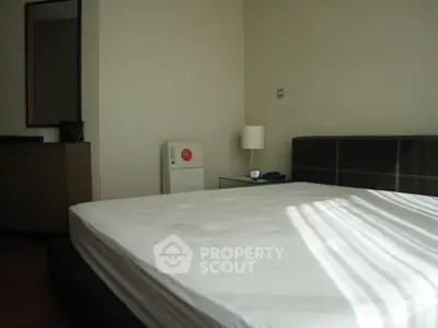 Spacious bedroom with modern decor and ample natural light