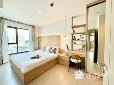 Modern bedroom with city view, stylish decor, and natural light in high-rise apartment.