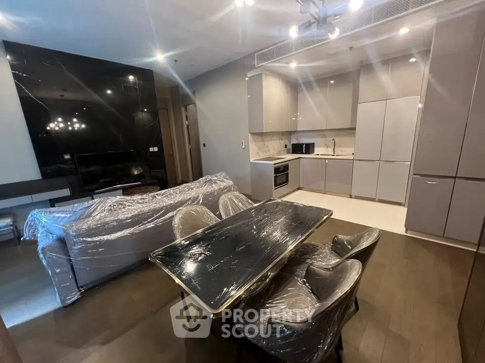 Modern open-plan living room and kitchen with sleek furniture and appliances.