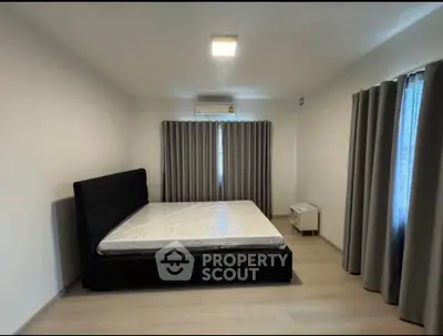 Spacious bedroom with modern design and large windows for natural light.