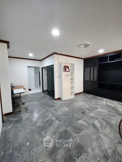 Spacious modern living room with marble flooring and built-in shelving