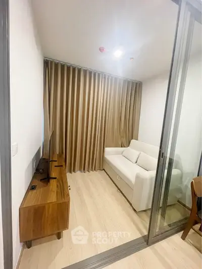 Cozy living room with modern sofa and wooden TV stand, perfect for relaxation.
