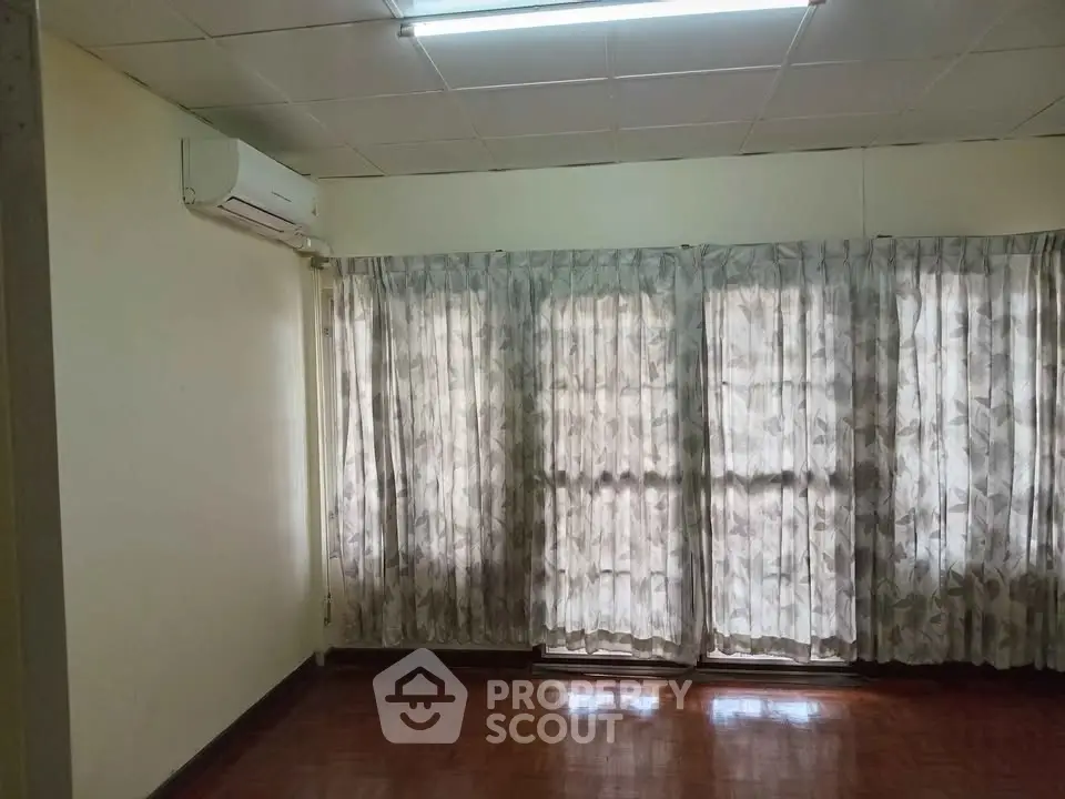Spacious room with large windows and air conditioning unit