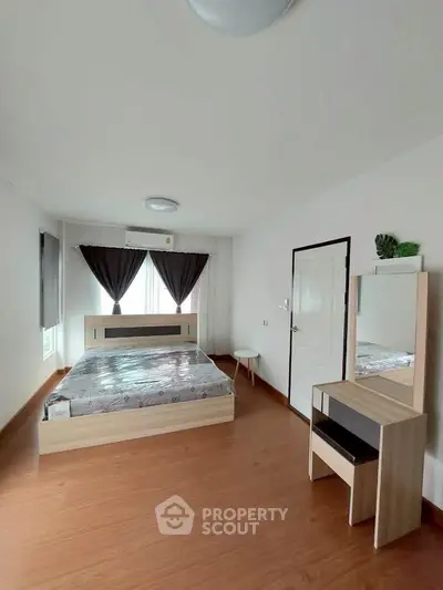 Spacious bedroom with modern furnishings and natural light