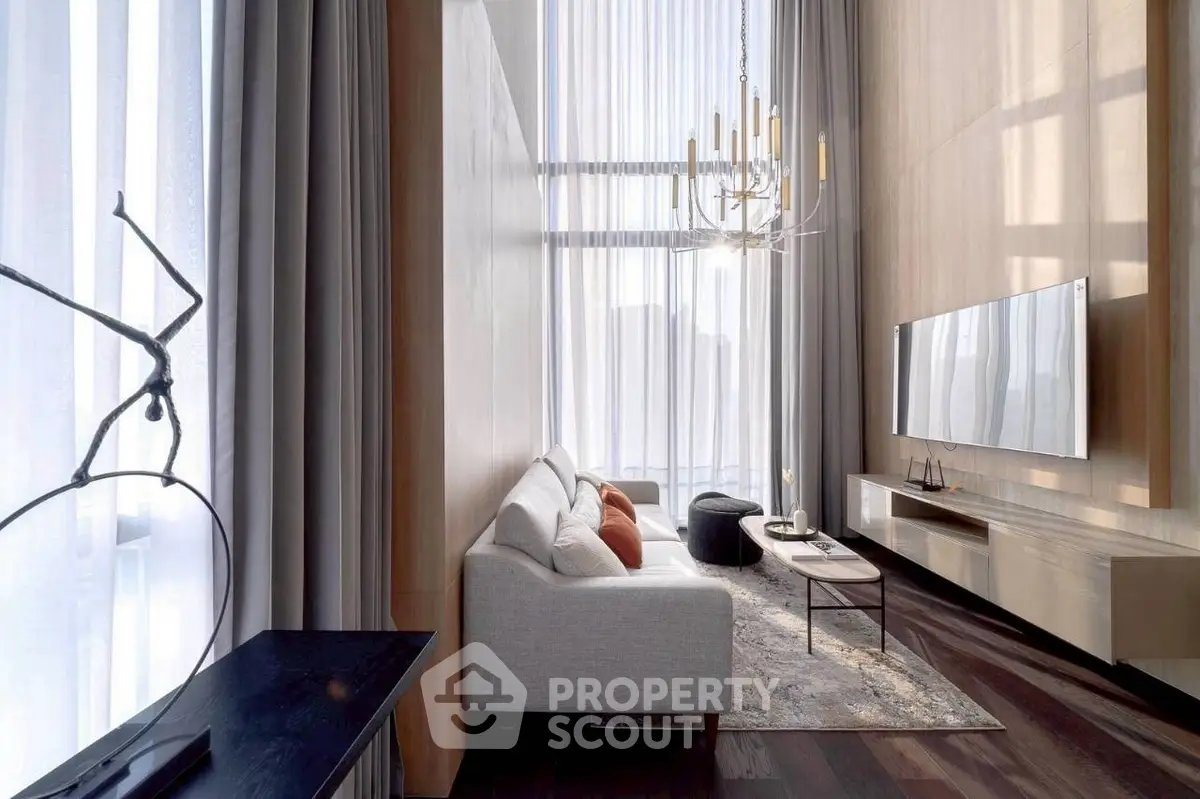 Luxurious modern living room with high ceilings, elegant chandelier, and floor-to-ceiling windows.