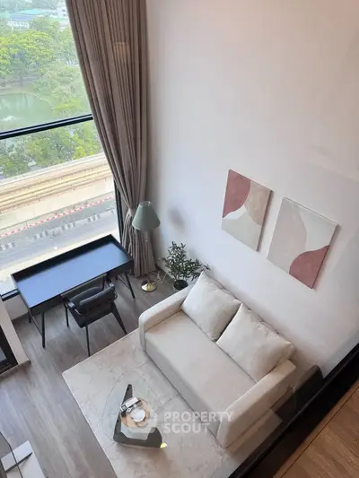 Modern living room with large window and stylish decor overlooking scenic view.