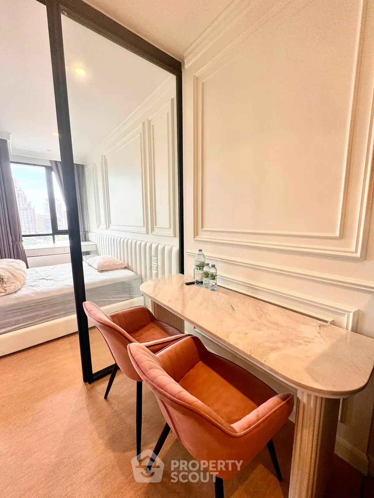 Luxurious bedroom with elegant decor and stylish furniture, featuring a cozy workspace and a stunning city view.
