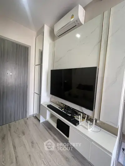 Modern living room with sleek TV setup and air conditioning unit.