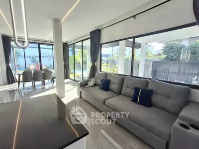 Spacious modern living room with large windows and elegant dining area