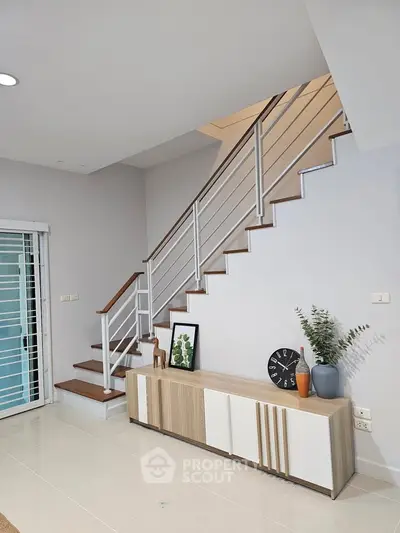 Modern interior with stylish staircase and sleek storage unit in a contemporary home.