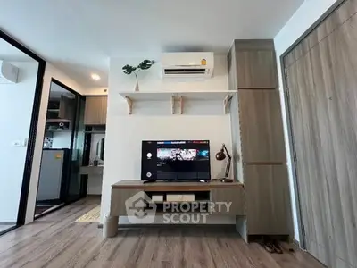 Modern living room with sleek furniture and wall-mounted TV in a stylish apartment.