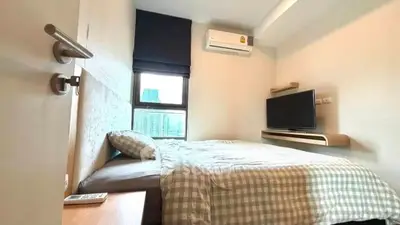 Cozy bedroom with city view, featuring modern decor and air conditioning, perfect for urban living.