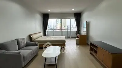 Spacious studio apartment with modern furnishings and city view.