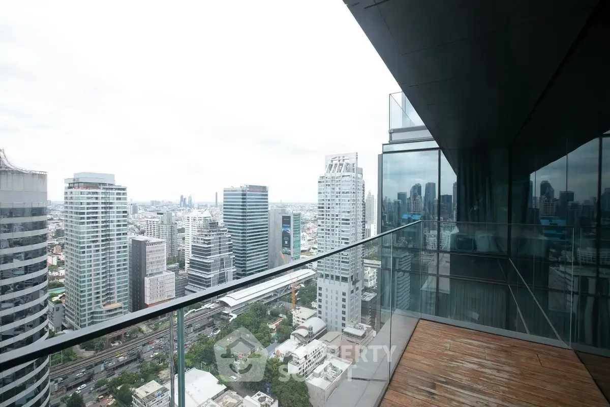 Stunning cityscape view from a modern high-rise balcony with glass railing and wooden flooring.