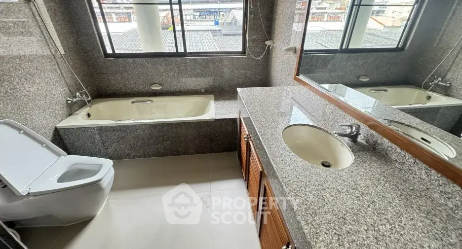 Spacious bathroom with granite countertops and bathtub in modern home