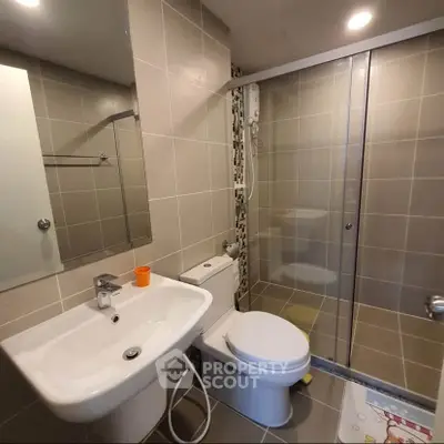 Modern bathroom with sleek fixtures and spacious shower in contemporary apartment.