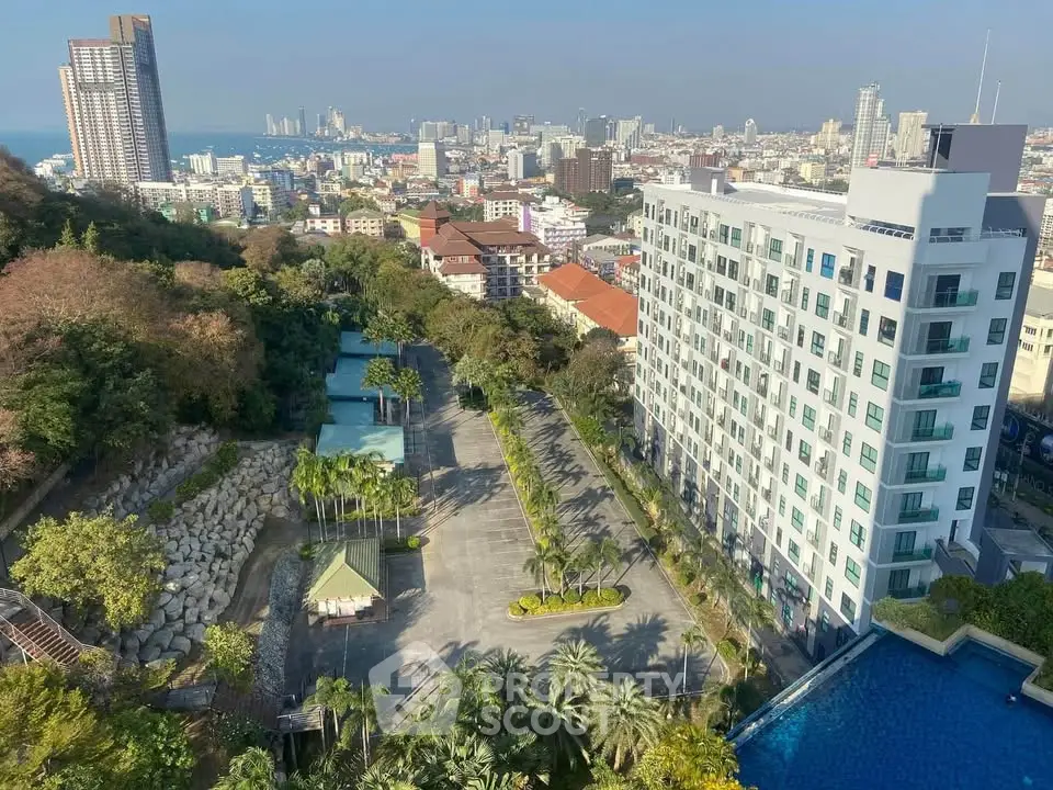 Stunning cityscape view from high-rise building with pool and lush greenery