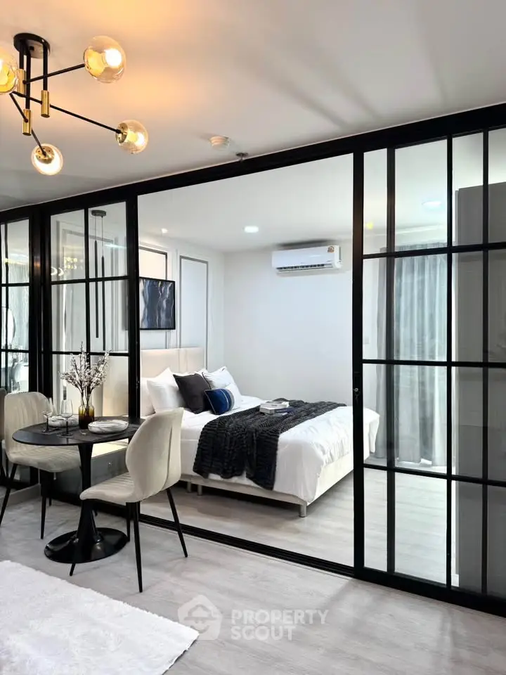 Modern apartment with glass partition, cozy bedroom, and elegant dining area.