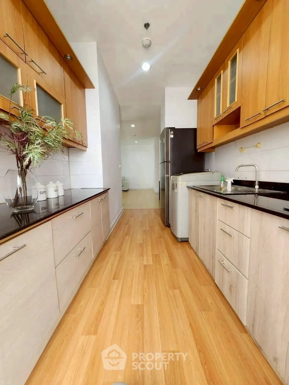 Spacious modern kitchen with sleek cabinetry and wooden flooring