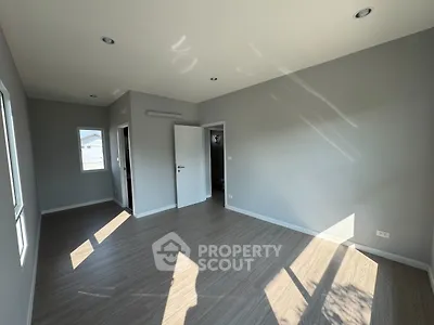 Spacious empty room with large windows and modern flooring, perfect for customization.