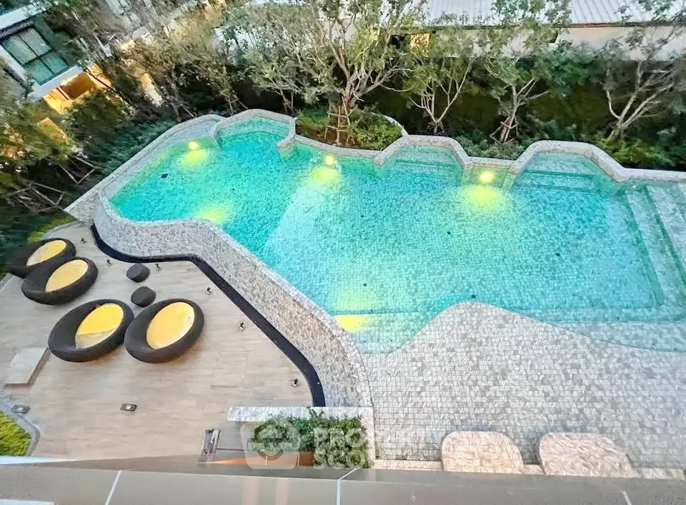 Luxurious outdoor pool area with stylish seating and lush greenery, perfect for relaxation and leisure.