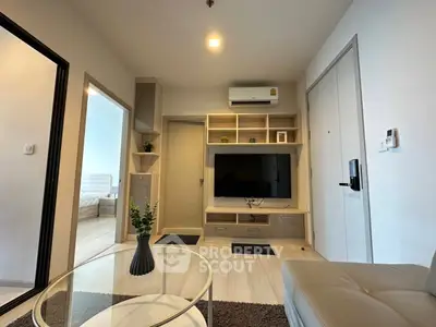 Modern living room with sleek furniture and wall-mounted TV in a cozy apartment setting.