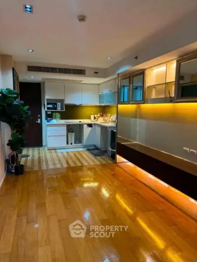 Modern open-layout kitchen with wooden flooring and stylish lighting