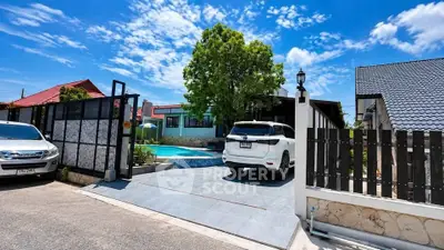 Charming suburban home with private pool and spacious driveway under a clear blue sky.