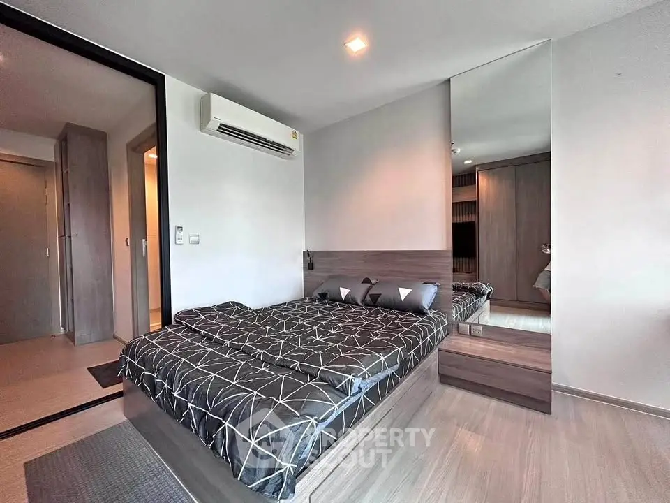 Modern bedroom with stylish decor and mirrored wardrobe in a contemporary apartment.