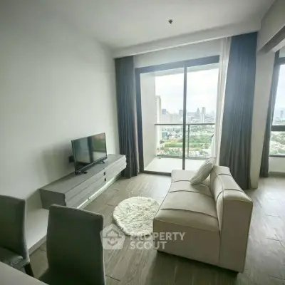 Modern living room with city view, featuring sleek furniture and large windows for natural light.