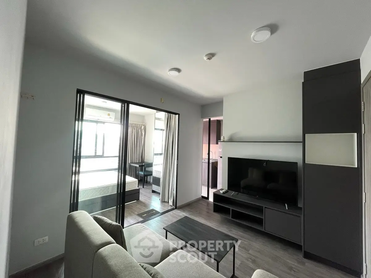 Modern living room with sleek furniture and large windows in a stylish apartment.