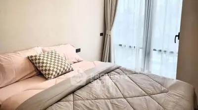Cozy bedroom with soft bedding and large window offering natural light.