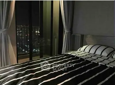 Stylish bedroom with city view and modern striped bedding