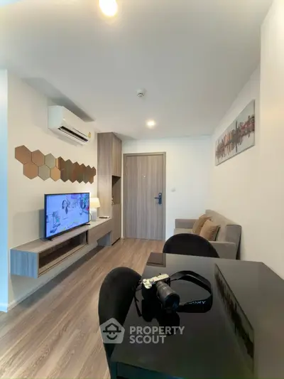 Modern living room with stylish decor, wall-mounted TV, and cozy seating area in a contemporary apartment.