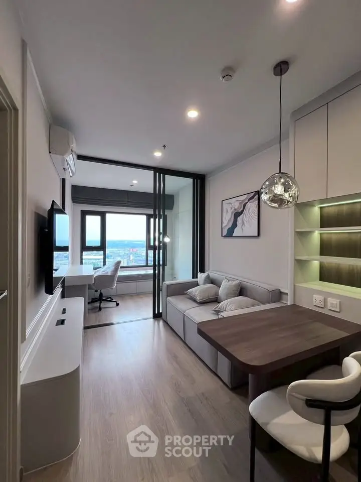 Modern living room with stylish decor and open layout, featuring a cozy sofa and elegant dining area.