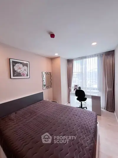 Modern bedroom with large window and stylish decor, featuring a cozy bed and a sleek desk setup.
