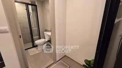 Modern bathroom with sleek shower and toilet in contemporary apartment.