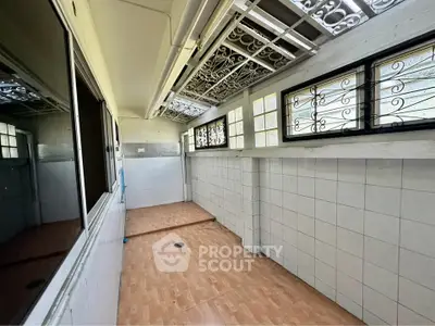 Spacious tiled room with large windows and decorative ceiling grilles