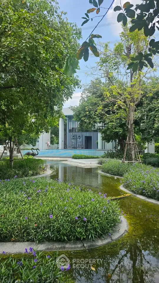Luxurious garden view with serene water features and lush greenery in a modern real estate setting.