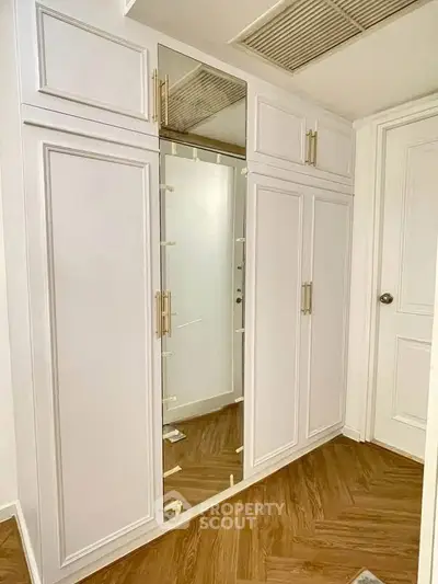 Elegant built-in storage with mirrored door and sleek handles in modern home interior.