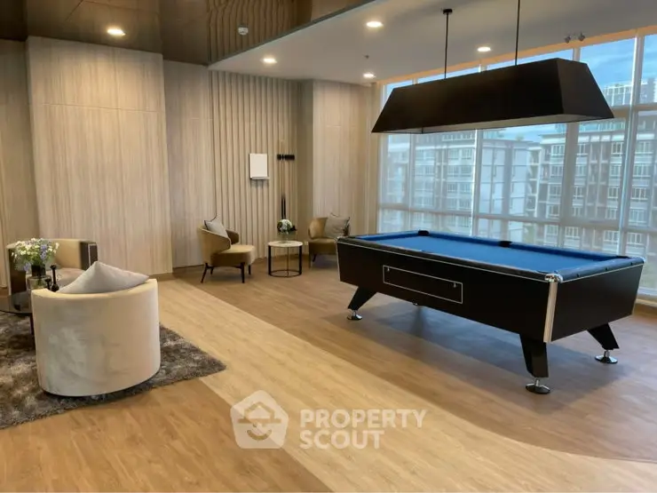 Luxurious common area with pool table and seating, featuring large windows and modern decor.