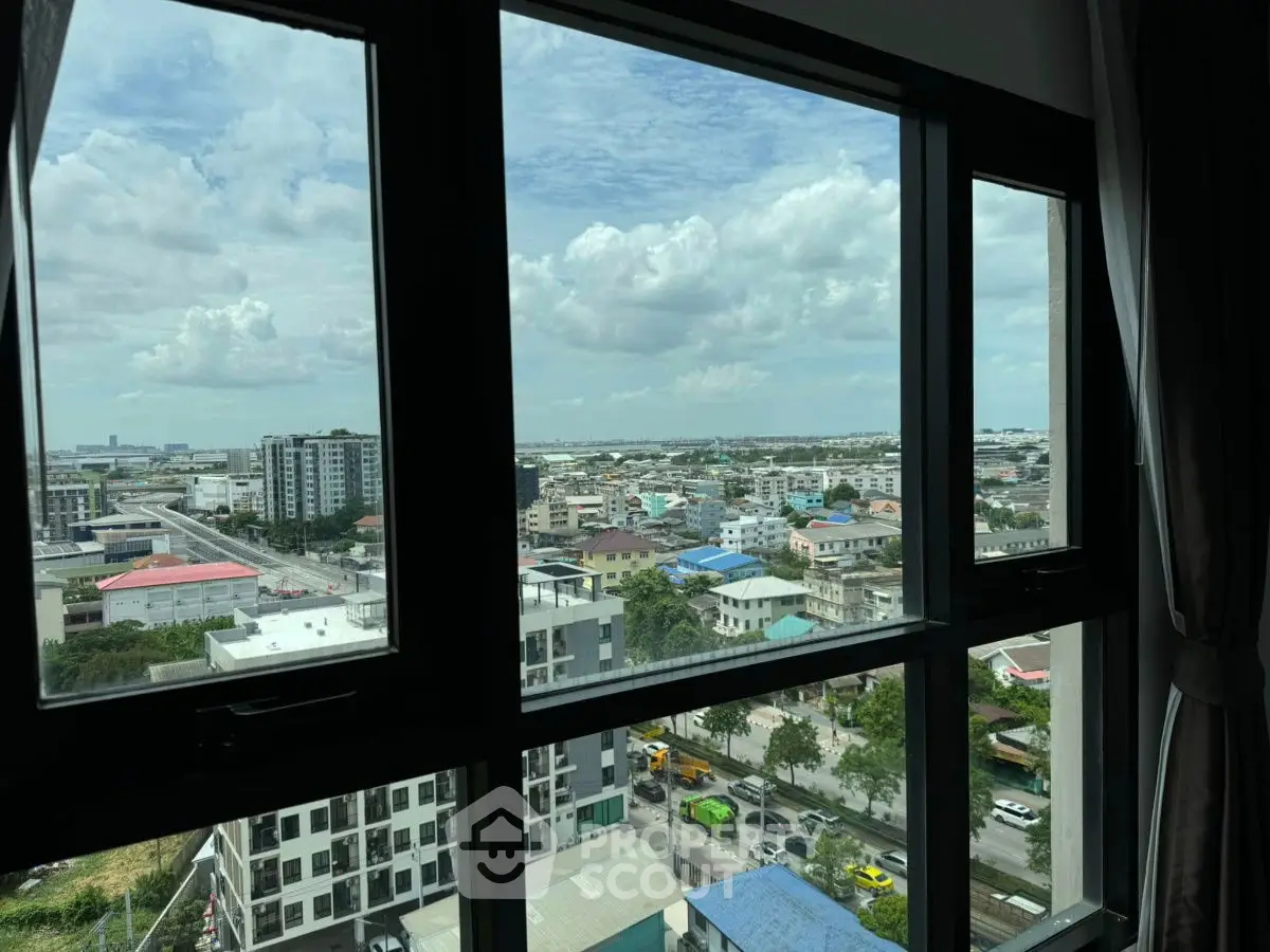 Stunning cityscape view from high-rise apartment window with expansive skyline.
