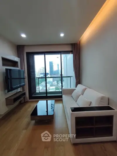 Modern living room with city view, sleek furniture, and large windows for natural light.