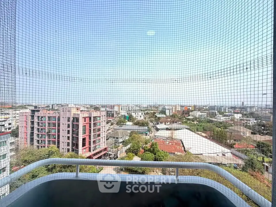 Stunning cityscape view from a high-rise balcony with safety netting, showcasing urban living at its finest.
