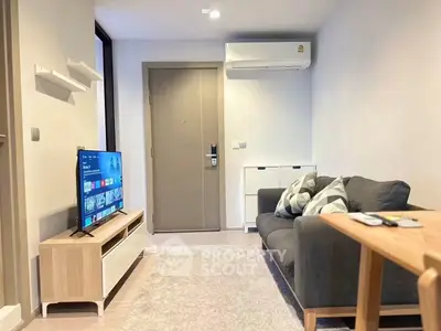 Cozy modern living room with sleek furniture and wall-mounted TV, perfect for relaxation.