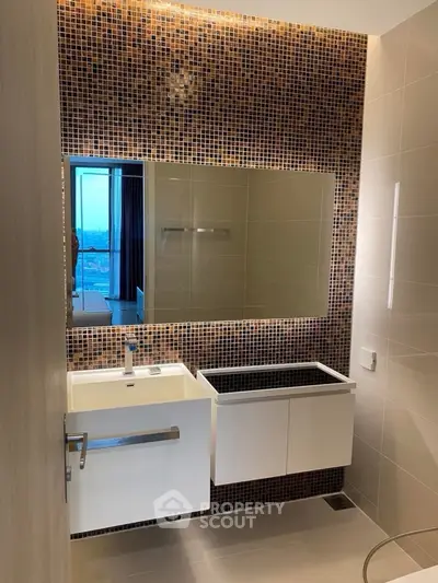 Modern bathroom with mosaic tile wall and sleek fixtures